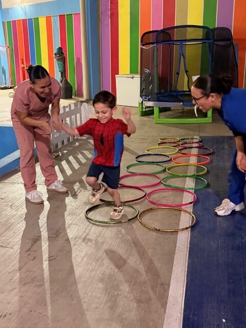 Niño recorriendo un circuito de aros acompañado por especialistas en Baby Bloom